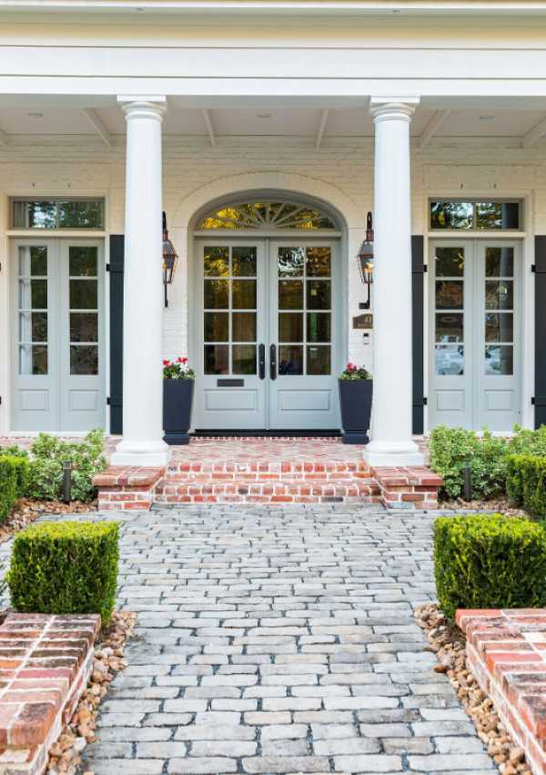 Desain rumah dengan jendela-jendela besar dan lengkungan elegan yang menghadirkan nuansa klasik yang memesona